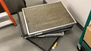 Grease-covered commercial kitchen exhaust filters prepared for professional hood cleaning and NFPA 96 kitchen exhaust maintenance