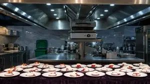 Professional commercial kitchen with stainless steel exhaust hood and freshly plated desserts, highlighting a clean restaurant kitchen environment