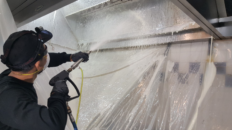 Kitchen Hood Cleaning Tech Spraying Hood